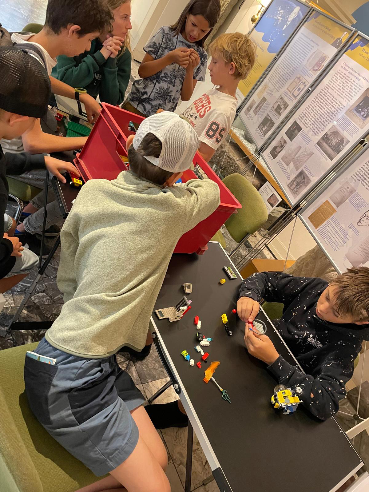 Ein Kind greift in eine Kiste und holt einen Baustein.