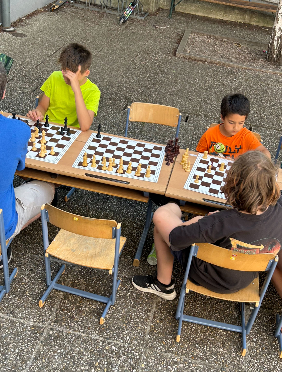 Kinder sitzen gegenüber und spielen miteinander Schach