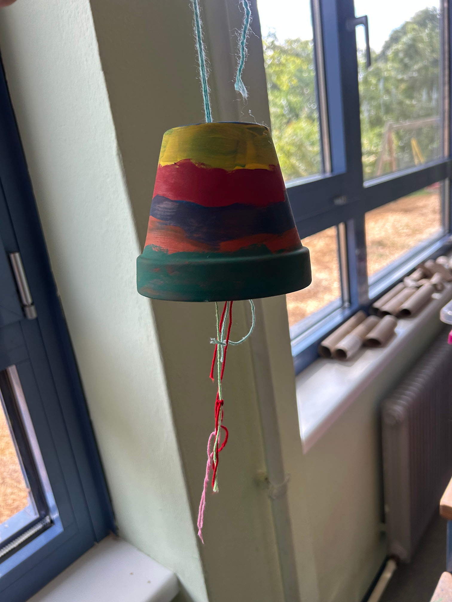 ein bunt bemalter Blumentopf als Windspiel
