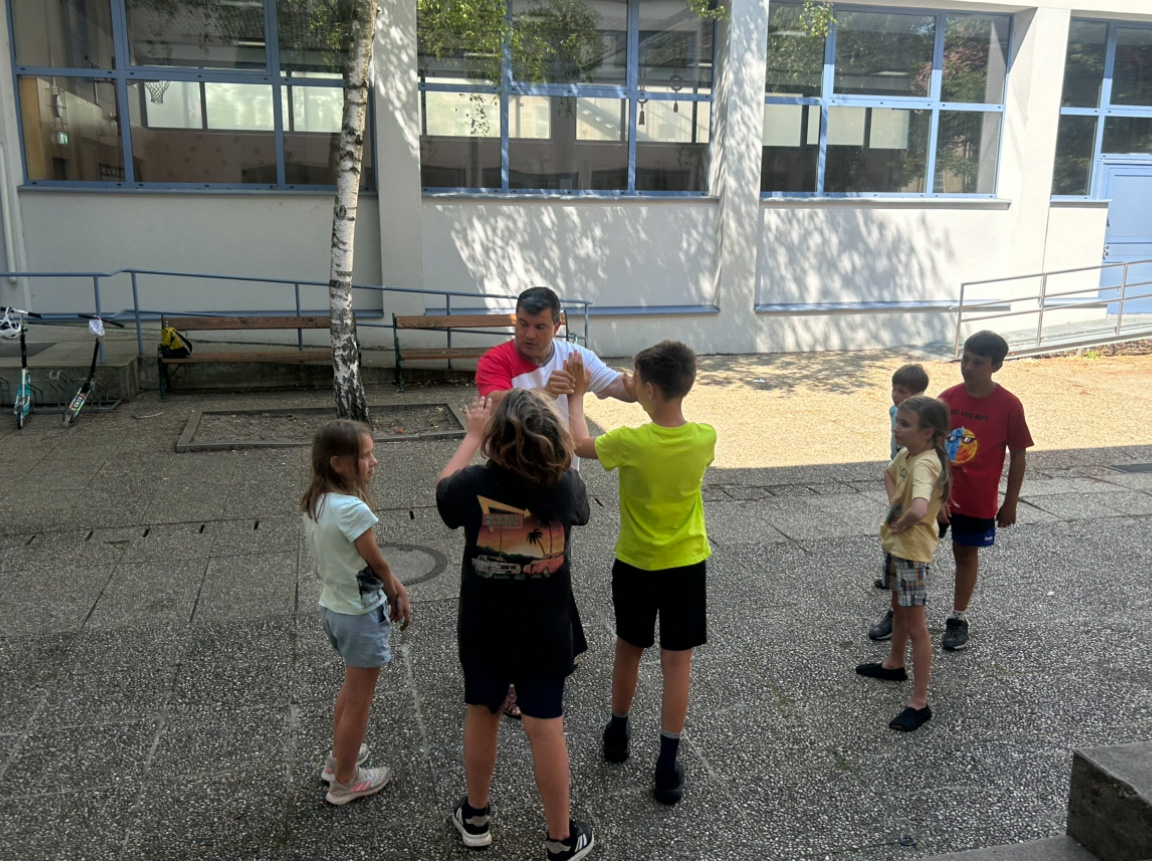 Ein Erwachsener bringt einer Gruppe von Kindern Selbstverteidigung bei.