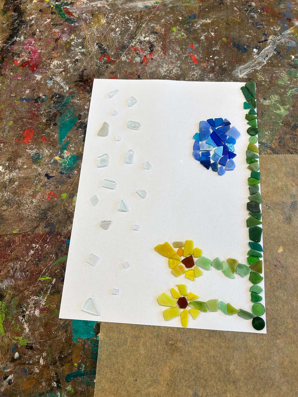 Ein Blumenbild aus Steinen auf weißem Papier