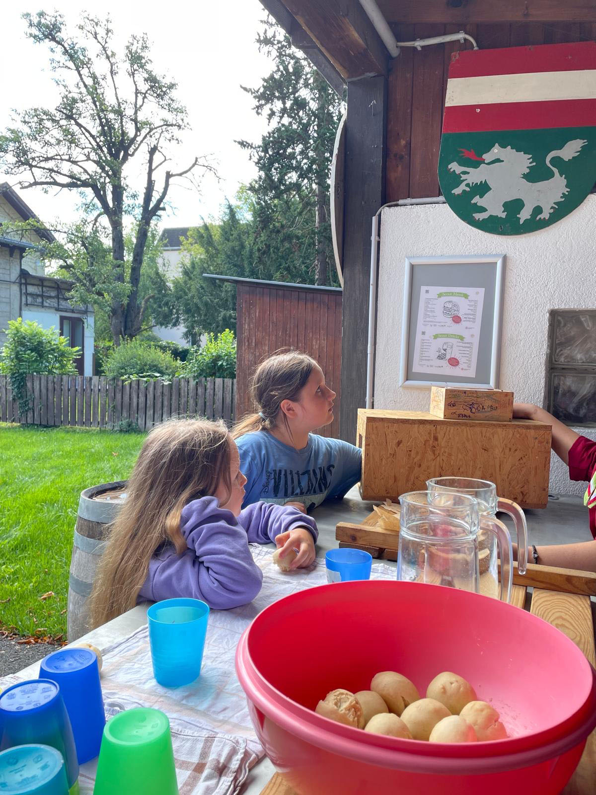 Zwei Kinder sitzen an einem Tisch und hören jemandem gespannt zu