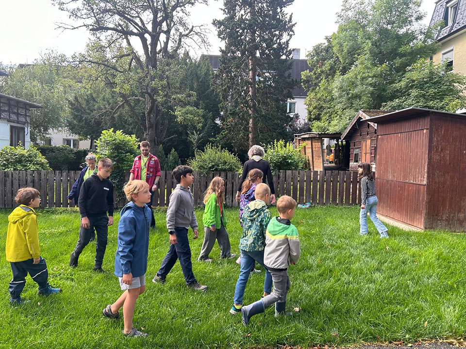 Eine Gruppe an Kindern geht im Garten umher
