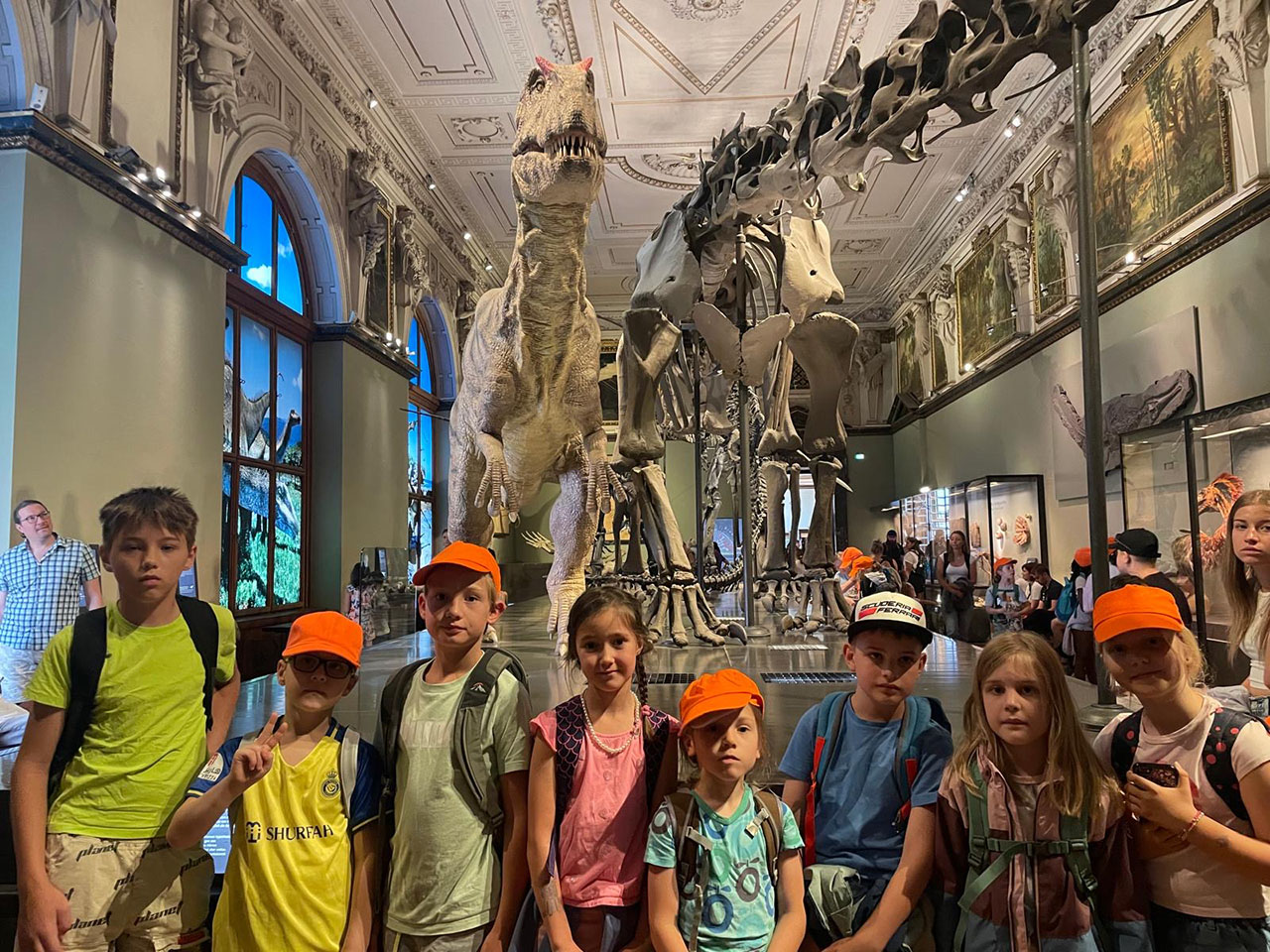 Eine Gruppe an Kindern steht vor dem Skelett eines Dinosauriers