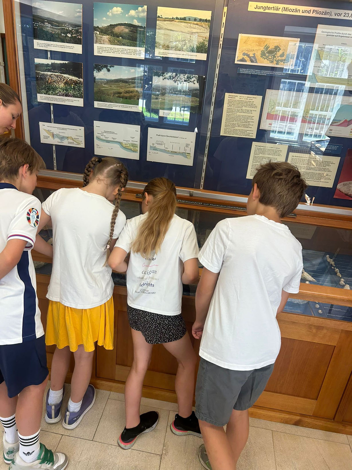 Ein paar Kindern sieht in einen Schaukasten