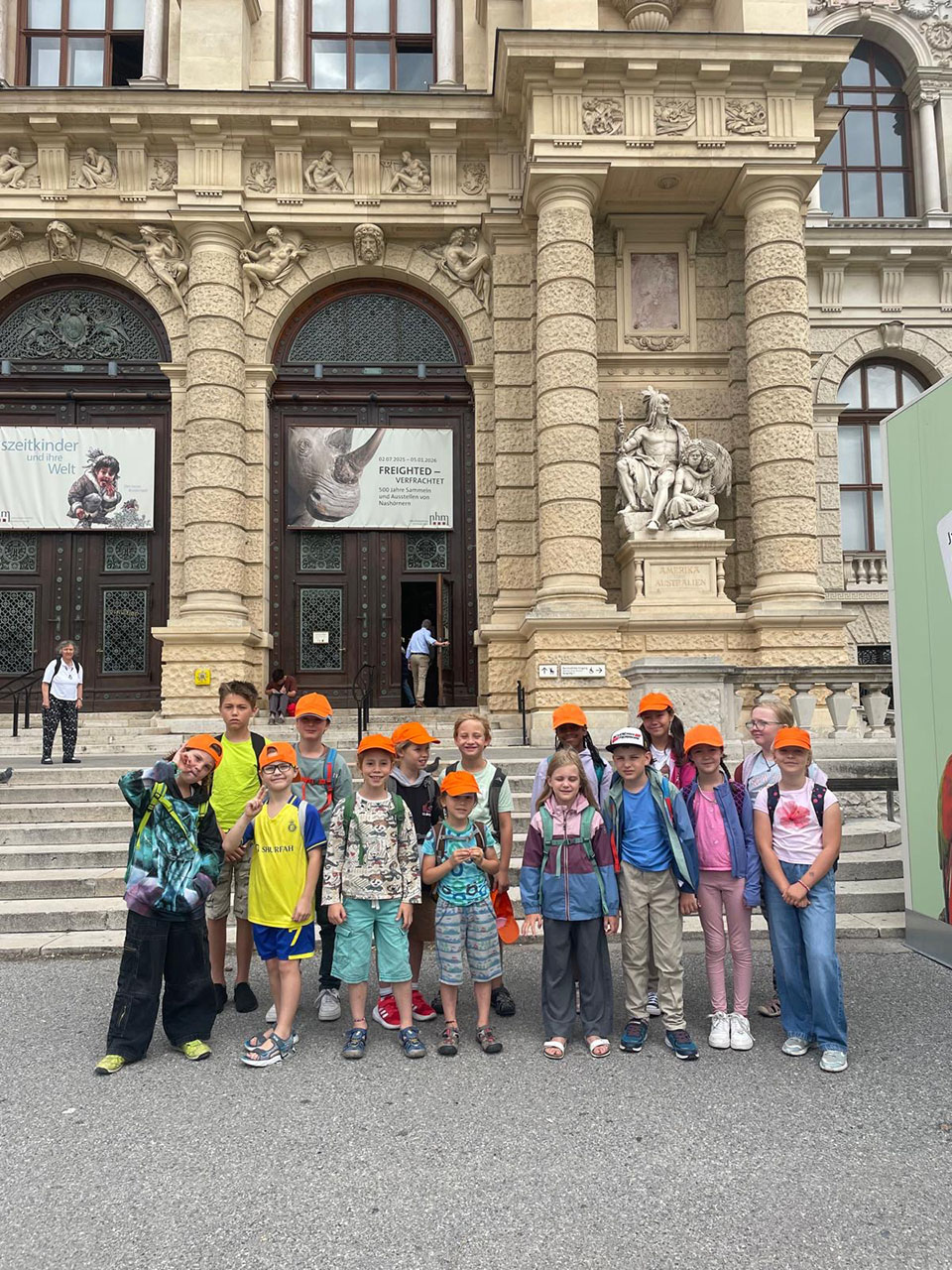 Eine Gruppe an Kindern steht vor einem Gebäude